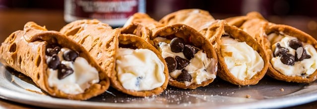 closeup image of five cannolis side by side